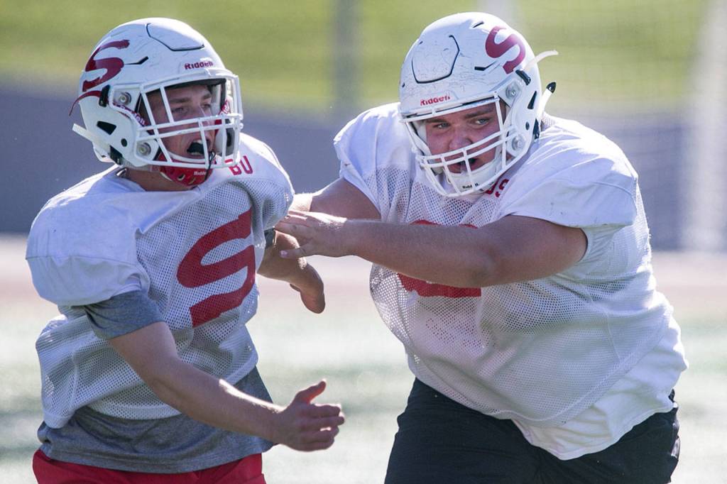 Brayden Ulrich (left) is blocked by Derek Stultz Thursday afternoon during practice at Veterans Memorial Stadium in Snohomish on September 27, 2018 (Kevin Clark / The Herald)