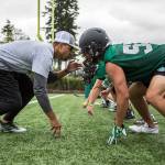 Coach JR Wells gets in a defensive stance against Exavier Bonifacio during the first day of Jackson High School football practice on Wednesday, Aug. 21, 2019 in Mill Creek, Wash. (Olivia Vanni / The Herald)