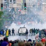On Nov. 30 1999, Seattle police use tear gas to push back World Trade Organization protesters downtown. Saturday marks 20 years since tens of thousands of protesters converged on Seattle and disrupted a major meeting of the World Trade Organization. Two decades later, many of their causes are still relevant. (AP Photo/Eric Draper, File)
