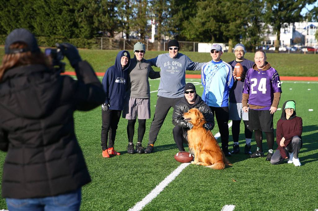 The 25th annual touch football game starts with a group photo Saturday morning at Cascade High School in Everett. (Kevin Clark / The Herald)