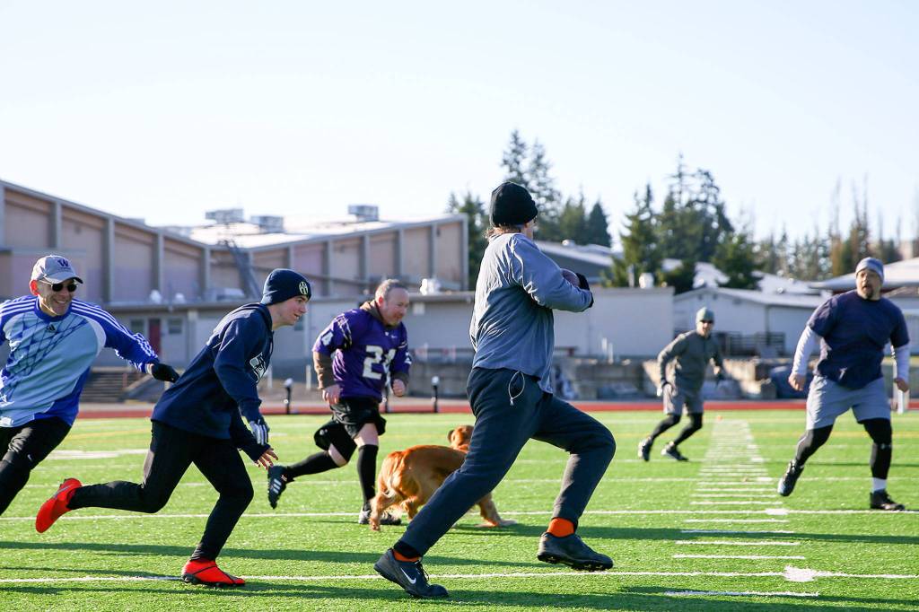 Friends from high school, now in their 50s, play in an annual post-Thanksgiving touch football game Saturday morning at Cascade High School in Everett. (Kevin Clark / The Herald)