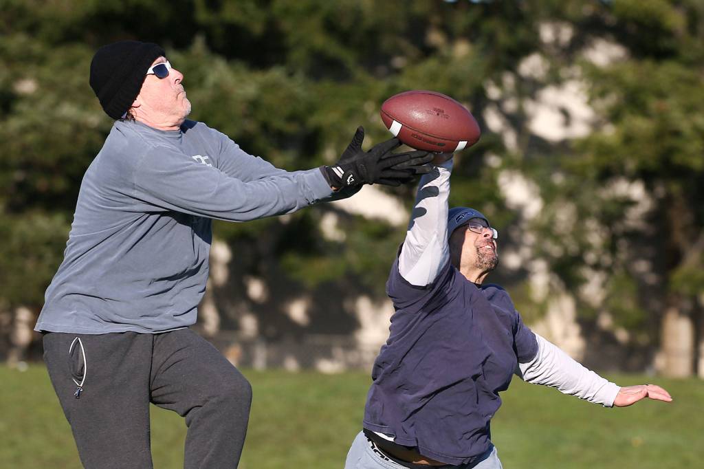 Kevin Sullivan (center) is touched down by Jason Carman (right) Saturday afternoon at Cascade High School in Everett. (Kevin Clark / The Herald)