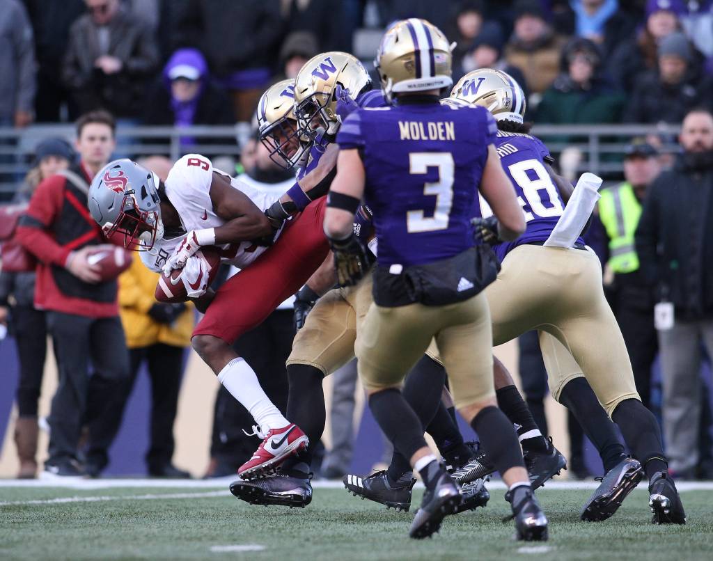 Washington State Cougars wide receiver Renard Bell (9) is stopped after a catch by the Huskies defense. The Washington State University Cougars lost 31-13 to the University of Washington Huskies in the 112th Apple Cup at Husky Stadium on Friday, Nov. 29, 2019 in Seattle, Wash. (Andy Bronson / The Herald)