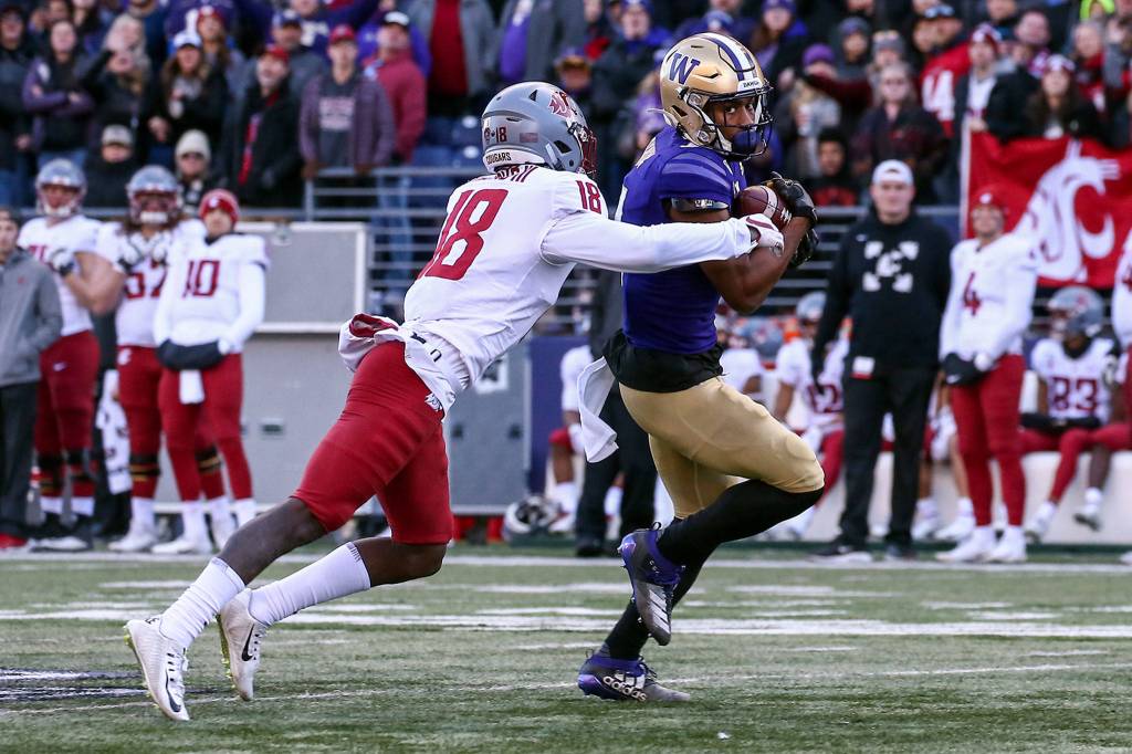 Washington Huskies wide receiver Terrell Bynum runs for extra yards after a reception with Washington State Cougars cornerback George Hicks III trailing during the 112th Apple Cup Friday afternoon at Alaska Airlines at Husky Stadium on November 29, 2019. The Huskies won 31-13. (Kevin Clark / The Herald)