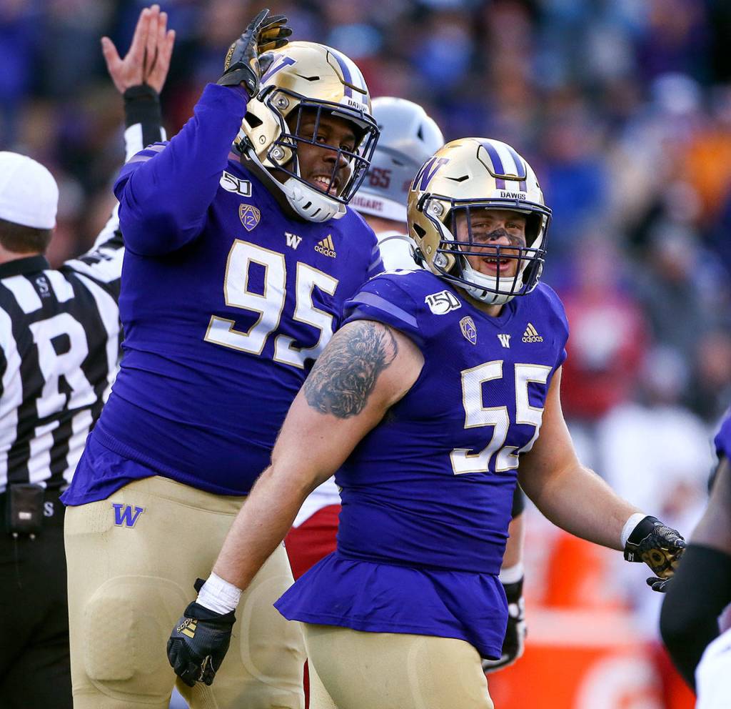 Washington Huskies defensive lineman Levi Onwuzurike (95) and Washington Huskies linebacker Ryan Bowman (55) celebrate a sack during the 112th Apple Cup Friday afternoon at Alaska Airlines at Husky Stadium on November 29, 2019. The Huskies won 31-13. (Kevin Clark / The Herald)
