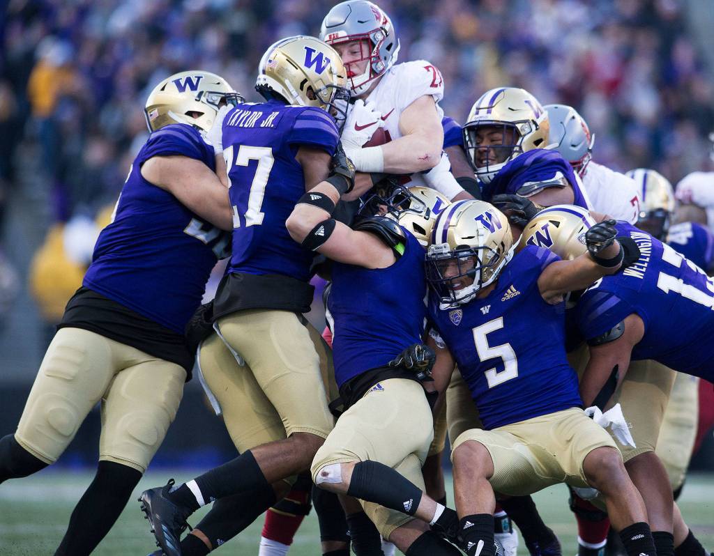Washington State Cougars running back Max Borghi is wrapped up by the Huskies defense as the Cougars lost to the University of Washington Huskies 31-13 in the 112th Apple Cup at Husky Stadium on Friday, Nov. 29, 2019 in Seattle, Wash. (Andy Bronson / The Herald)