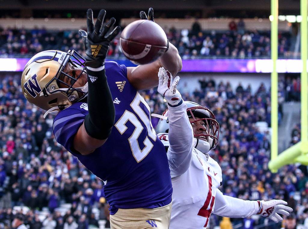 Washington Huskies wide receiver Ty Jones (20) attempts a catch with Washington State Cougars cornerback Marcus Strong (4) defending during the 112th Apple Cup Friday afternoon at Alaska Airlines at Husky Stadium on November 29, 2019. The Huskies won 31-13. (Kevin Clark / The Herald)