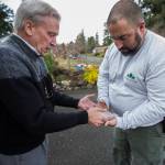 David Haarsager (left) hands Sprites paw impression to her owner, Wesley Clement. (Olivia Vanni / The Herald)