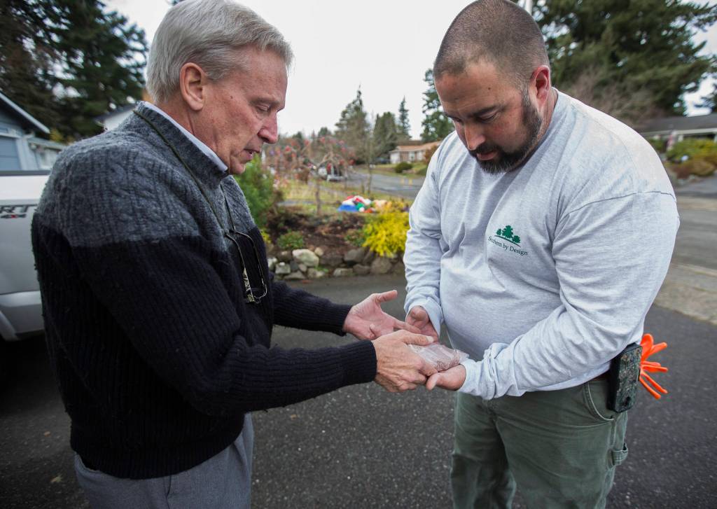 David Haarsager (left) hands Sprites paw impression to her owner, Wesley Clement. (Olivia Vanni / The Herald)