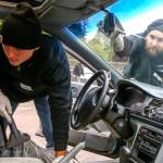 Josh James (left) vacuums while Nels Garberg repairs a chip in the window of a car at View Church in Snohomish in October. (Kevin Clark / The Herald)