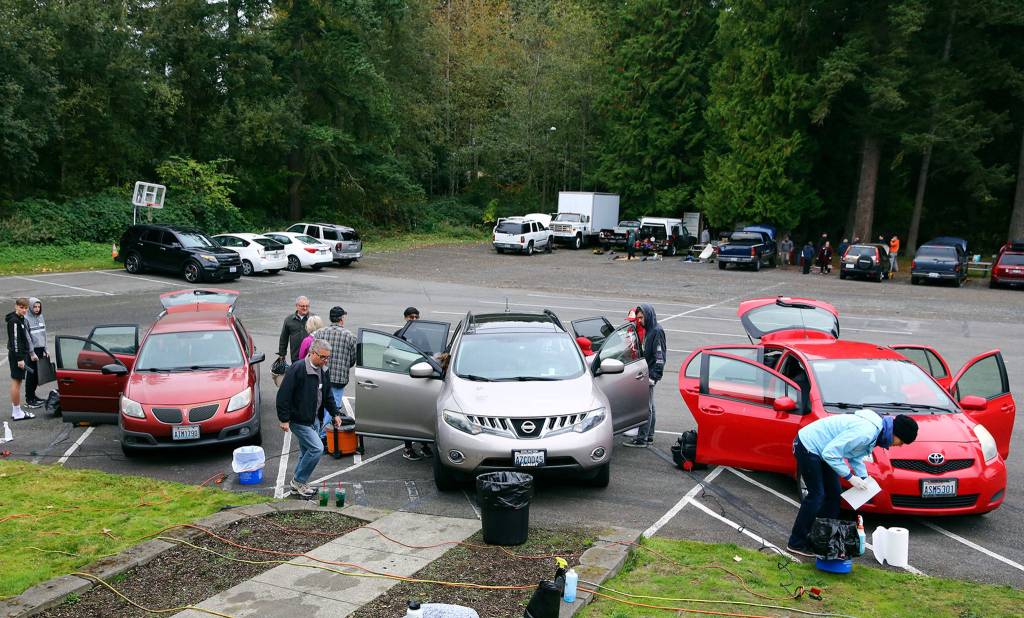 Volunteers detail a car at View Church in Snohomish in October. (Kevin Clark / The Herald)