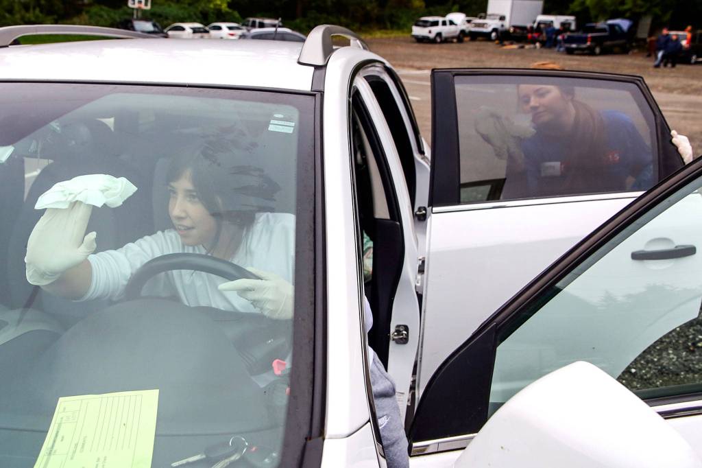 Brianna Phillips (left) and Shelby Lyon detail a car at View Church in Snohomish. (Kevin Clark / The Herald)