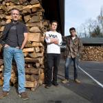 Shane McDaniel and his twin sons, Harrison and Henry, stand by wood stacked in front of their house in Lake Stevens to give to people in need. (Andy Bronson / The Herald)