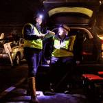 Gail Pyper (seated), a school nurse by day, talks with medical scribe Amanda Dahl near the Everett Public Library recently while on an evening outing with MercyWatch. (Dan Bates / The Herald)