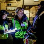 Gail Pyper, a school nurse by day, and her medical scribe Amanda Dahl talk with a man who came to a parking lot on Everetts Hoyt Avenue. (Dan Bates / The Herald)
