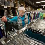 Volunteer Sandi Sharp picks out items to put on sale in a back room at the Assistance League of Everett. (Andy Bronson / The Herald)