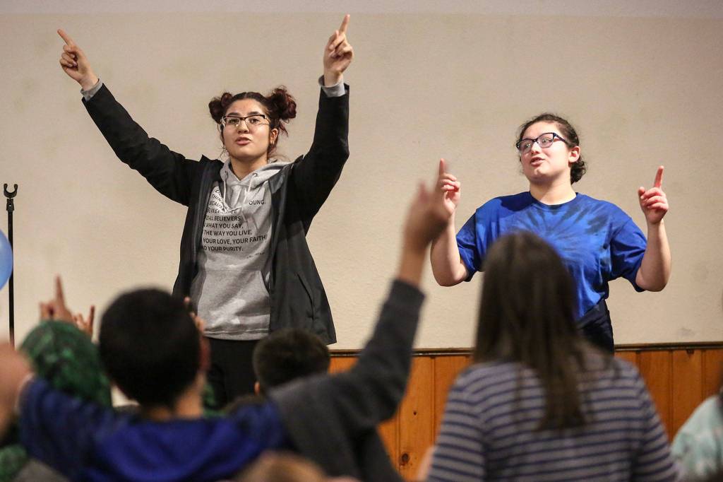 Michelle Guillen (left) and Victoria Castro leads Kidz Club in song in Monroe on Nov. 19. (Kevin Clark / The Herald)