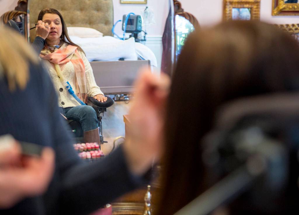 Lindsey Holland, a nurse, puts eye shadow on Loa Griesbach. (Olivia Vanni / The Herald)