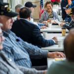 Angelita Shanahan, who volunteers and also sings the national anthem and birthday songs, chats with veterans before the start of the Heros Cafe at the Verdant Community Wellness Center on Nov. 26. (Olivia Vanni / The Herald)
