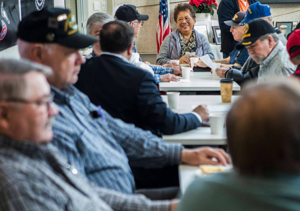 Angelita Shanahan, who volunteers and also sings the national anthem and birthday songs, chats with veterans before the start of the Heros Cafe at the Verdant Community Wellness Center on Nov. 26. (Olivia Vanni / The Herald)