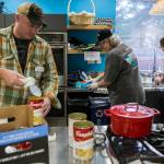 Aaron Slattery (left) opens cans of soup for lunch as volunteers prep food during the Heros Cafe at the Verdant Community Wellness Center on Nov. 26. (Olivia Vanni / The Herald)