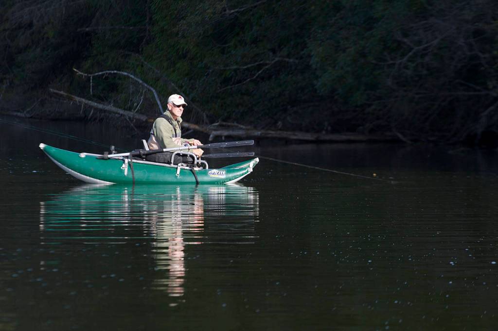 Chuck Morrison of Marysville enjoys a patch of sun while fishing Pass Lake on a fall day. (Mike Benbow)