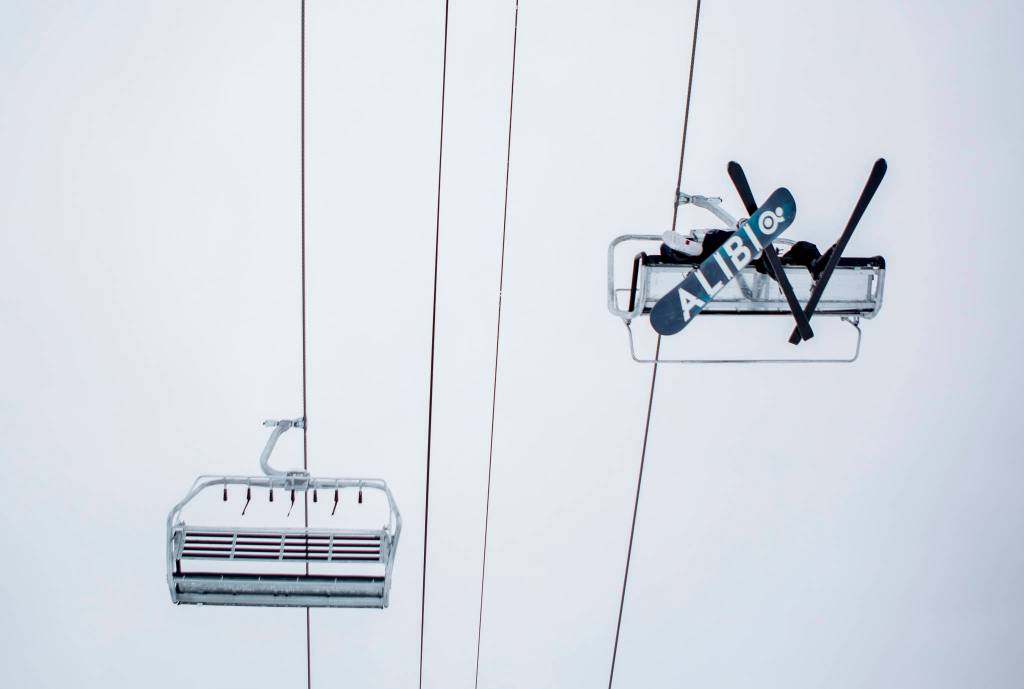 A skier and snowboarder ride the chairlift on opening day at Stevens Pass on Wednesday. (Olivia Vanni / The Herald)