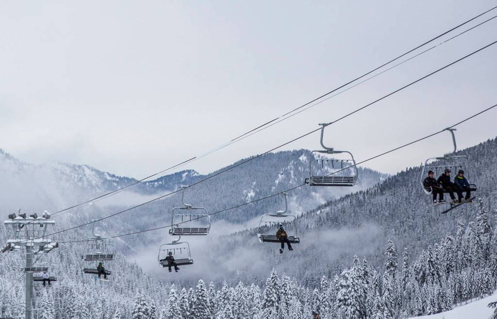 People ride the chairlift on opening day at Stevens Pass on Wednesday. (Olivia Vanni / The Herald)