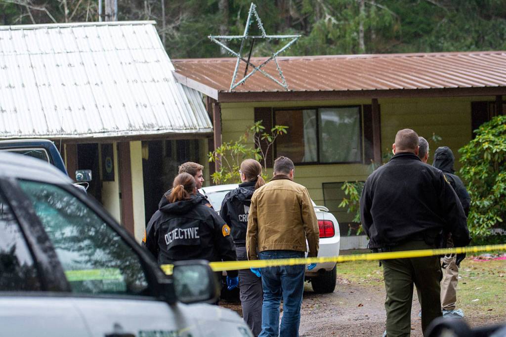 Investigators approach a home in Forks where Tristen Pisani, 19, was shot and killed Sunday. (Jesse Major / Peninsula Daily News)