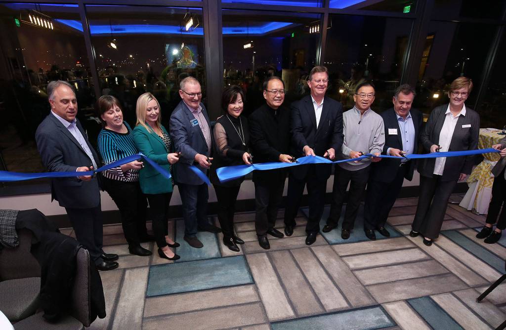 VIPs cut a ribbon to officially open the Hotel Indigo Everett during its grand ppening party on Wednesday. (Andy Bronson / The Herald)