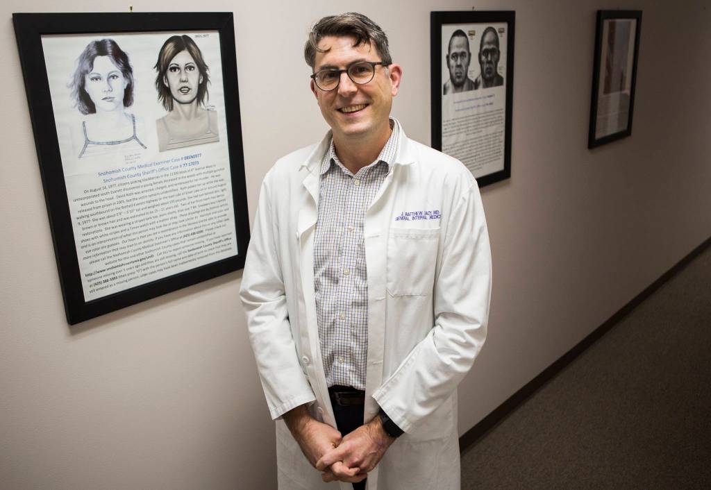 Dr. J. Matthew Lacy stands along a wall of cold cases at the Snohomish County Medical Examiners Office on Dec. 4 in Everett. (Olivia Vanni / The Herald)