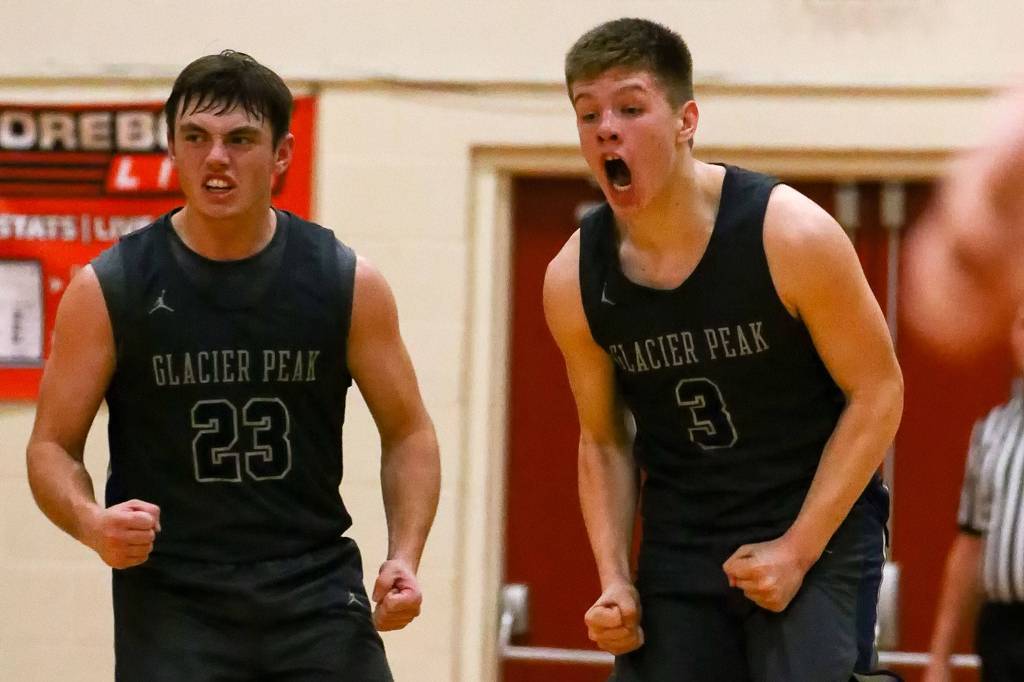 Glacier Peaks Brayden Corwin and Bobby Siebers celebrate a basket against Kings Friday evening at Kings School in Shoreline. The Grizzles won 58-53. (Kevin Clark / The Herald)