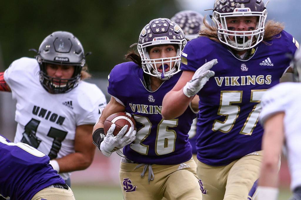 Lake Stevens receiver Sergio Pelayo (middle) follows blocker Austyn Rembold-Hyde. (Kevin Clark / The Herald)