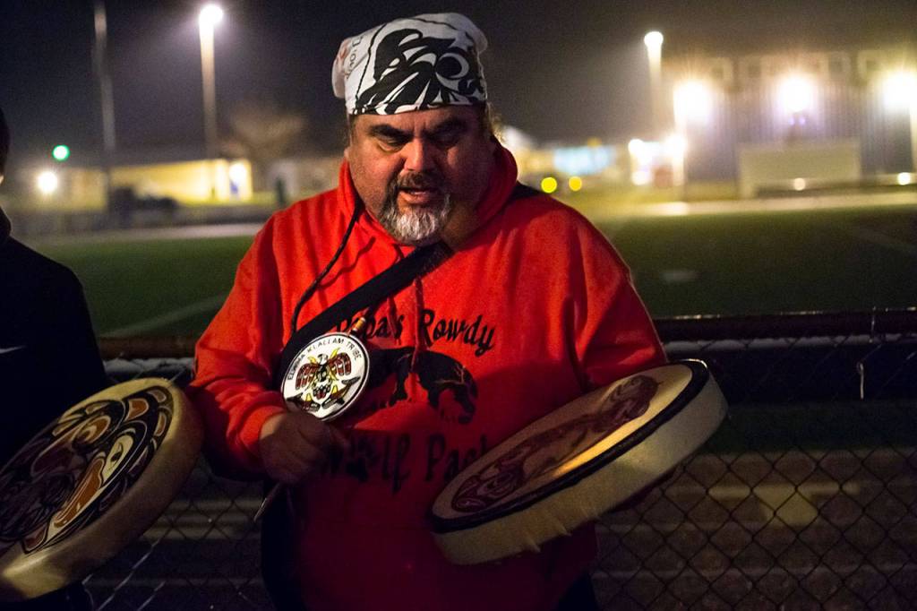 Mark Charles of the Lower Elwha Klallam Tribe leads a song during the vigil for Tristen Pisani at Spartan Stadium in Forks on Thursday. (Jesse Major / Peninsula Daily News)