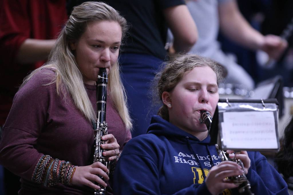 An Arlington band member looks over anothers shoulder while playing. The Arlington Eagles lost to the Lake Stevens Vikings 57-54 in a girls basketball game on Friday, Dec. 6, 2019 in Arlington, Wash. (Andy Bronson / The Herald)