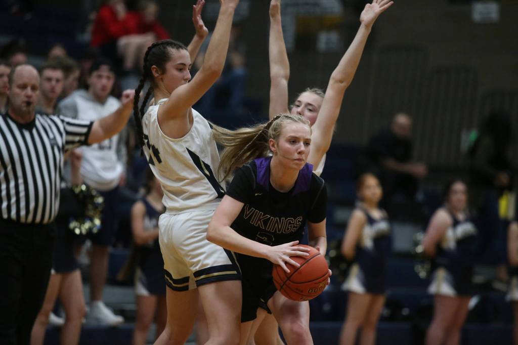 Lake Stevens Chloe Pattison squeezes through two Arlington defenders as the Arlington Eagles lost to the Lake Stevens Vikings 57-54 in a girls basketball game on Friday, Dec. 6, 2019 in Arlington, Wash. (Andy Bronson / The Herald)