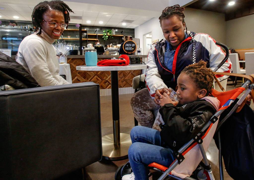 Everetts Bergie Dessius (left) smiles while watching her 3-year-old niece, Samora, who is with her mom, Jenny Alexandre, Dessius visiting sister from Boston. They were enjoying Fridays grand opening at Kindred Kitchen in Everett. (Dan Bates / The Herald)