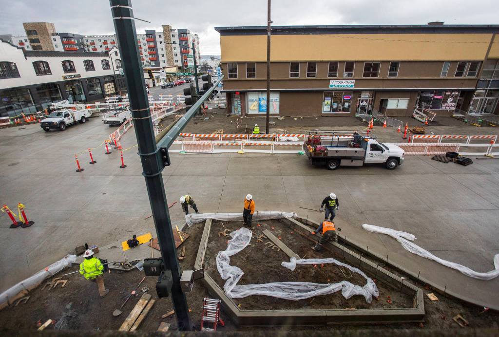 Construction workers rebuild the northeast corner of Hewitt and Rucker avenues on Thursday in Everett. (Olivia Vanni / The Herald)