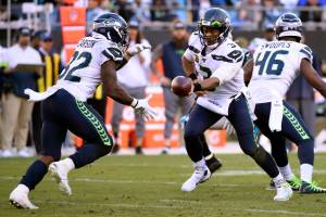 Seattle Seahawks quarterback Russell Wilson (3) hands off to running back Chris Carson during the second half of Sundays game against the Carolina Panthers. Carson rushed for 133 yards in the contest. (AP Photo/Mike McCarn)