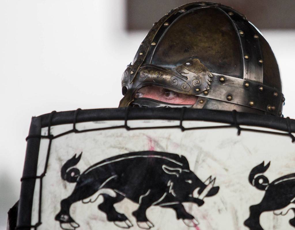 Timm Rulison, whose persona is Sir Timothy AP Caradoc, peers over the top of his shield during combat practice battle at Evergreen Middle School in Everett. (Olivia Vanni / The Herald)