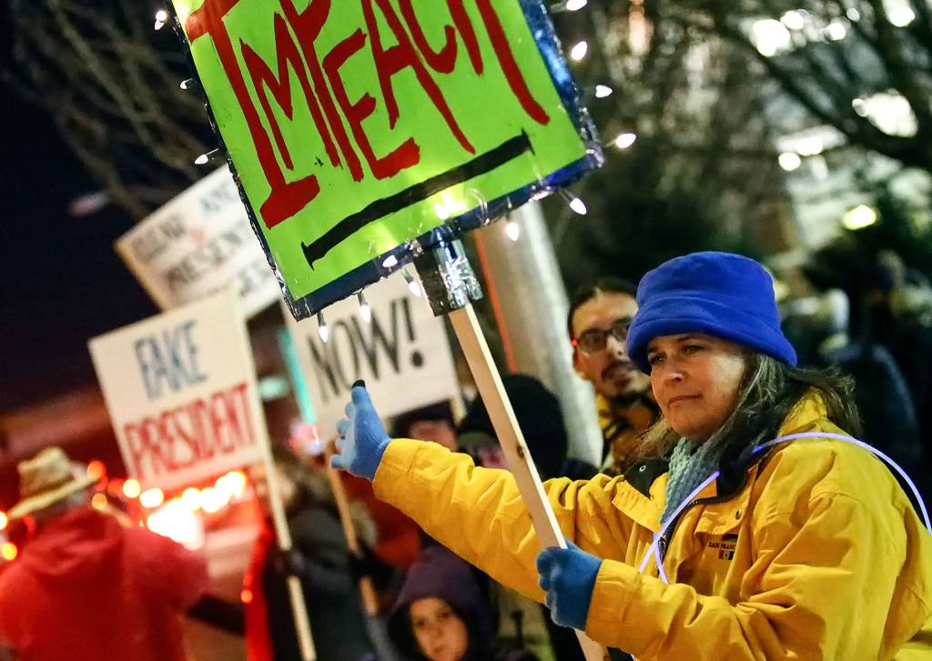 Hundreds gathered in support of the impeachment of President Donald Trump Tuesday evening along Broadway in Everett. (Kevin Clark / The Herald)