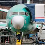 A worker and a Boeing 737 Max jet Monday in Renton. (AP Photo/Elaine Thompson)