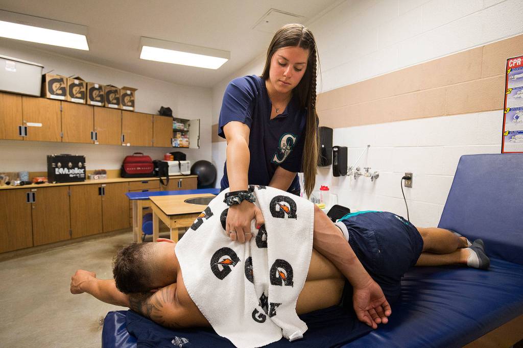 AquaSox athletic trainer Amanda Lee works on a players shoulder in the training room of the teams clubhouse on Aug. 13, 2019, in Everett. (Andy Bronson / The Herald)