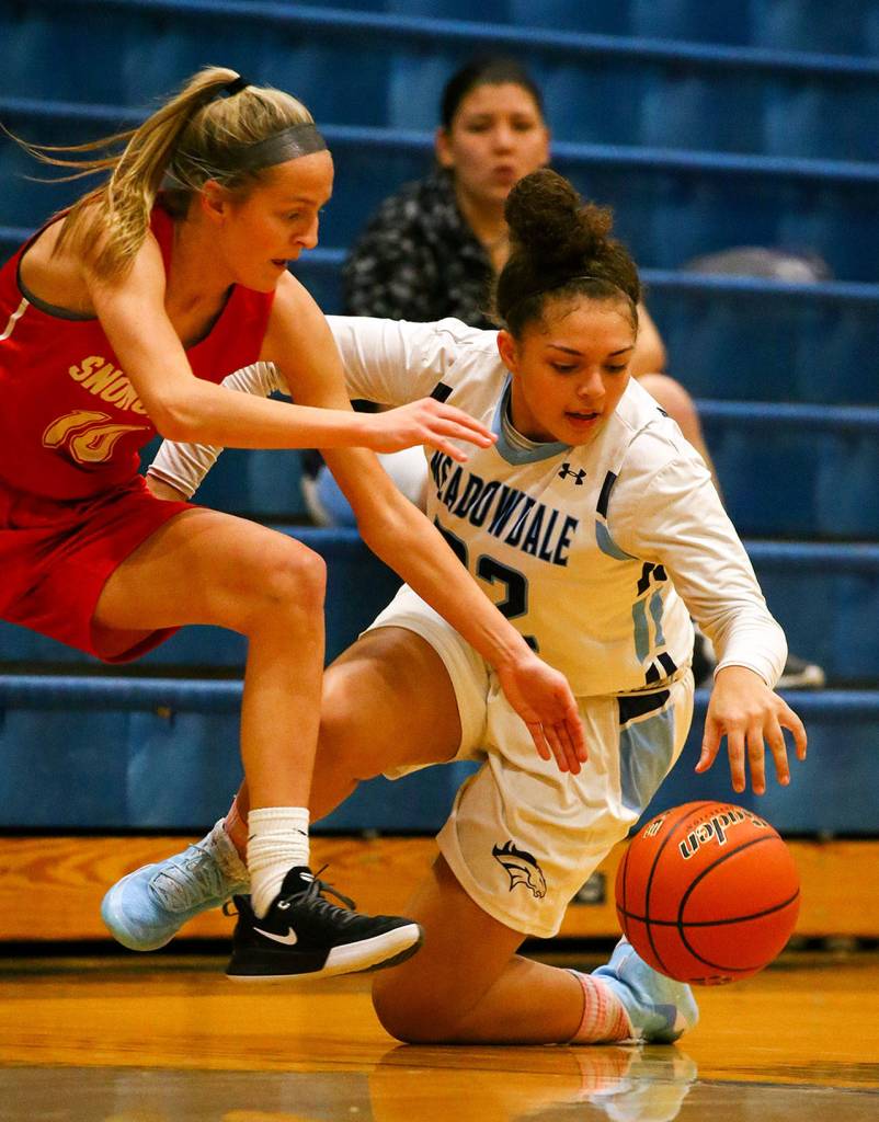 Snohomishs Kayla Soderstrom (left) and Meadowdales Soriah Swinton chase down a loose ball Tuesday evening at Meadowdale High School in Lynnwood. The Mavericks won 47-41. (Kevin Clark / The Herald)