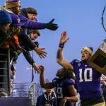 Washingtons Jacob Eason carries the trophy through the tunnel after the 112th Apple Cup at Husky Stadium on Nov. 29. The Huskies won 31-13. (Kevin Clark / The Herald)