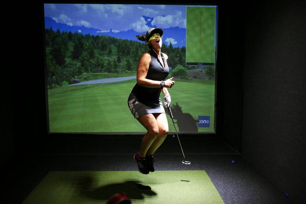 Gina Deutsch reacts to a missed putt as she and a teammate compete on the first day of league play golf at Back9 Parlor on Sept. 10 in Lynnwood. (Andy Bronson / The Herald)