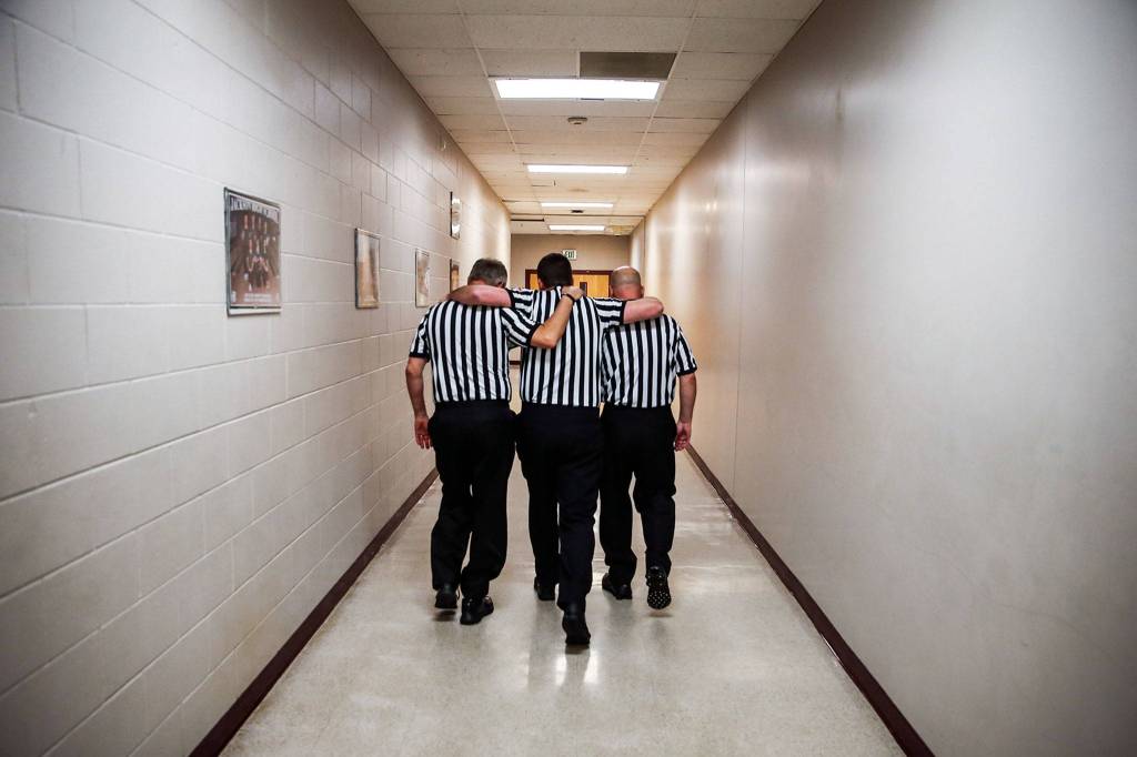 Steve Landro (left), Mark Myers (center) and Todd Weber make their way to Myers final game at Jackson High School in Mill Creek on Dec. 13. (Kevin Clark / The Herald)