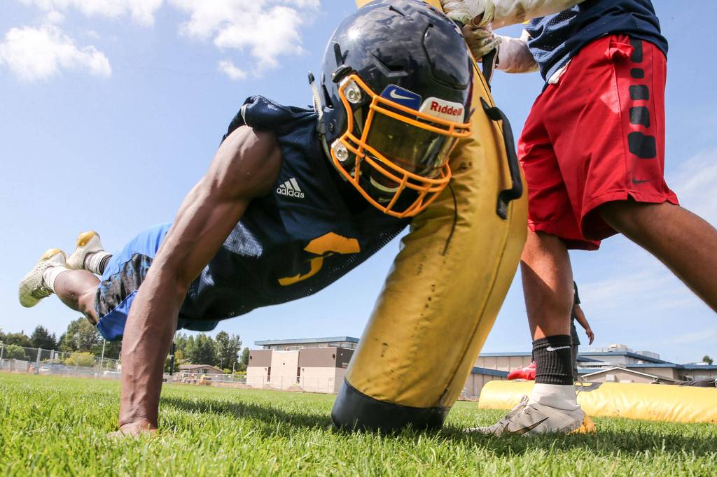 Sebastian Wanjiru runs through a tackling drill during practice at Mariner High School in Everett on Aug. 22. (Kevin Clark / The Herald)