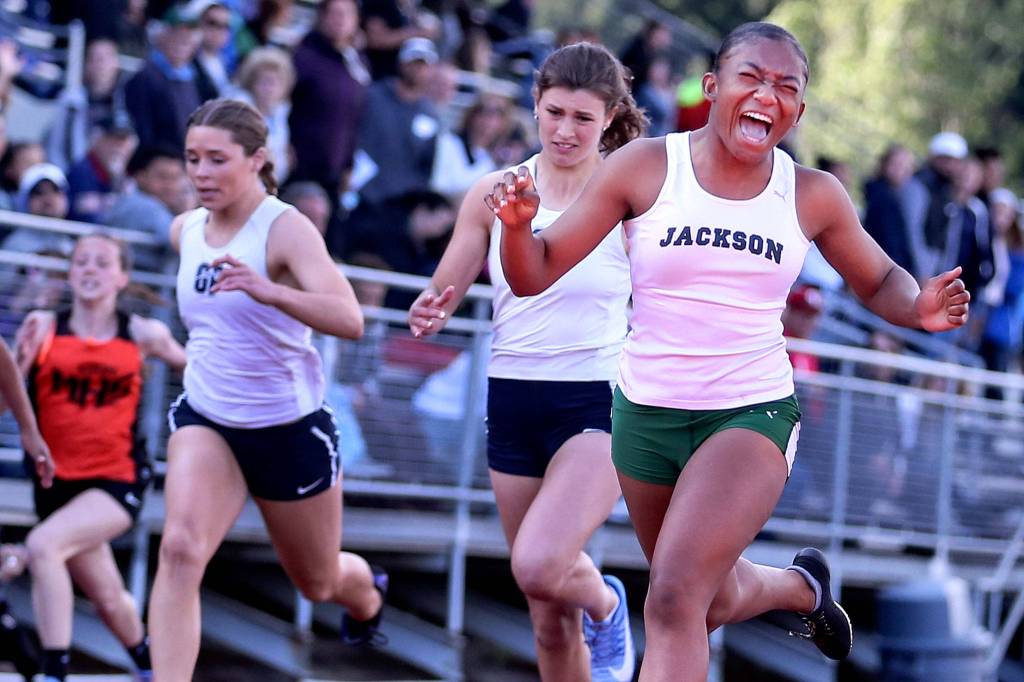 Jacksons Amaya Poole (right) celebrates after winning the 100-meter dash during the 3A & 4A NW District Track and Field Championships at Shoreline Stadium on May 17. (Kevin Clark / The Herald)