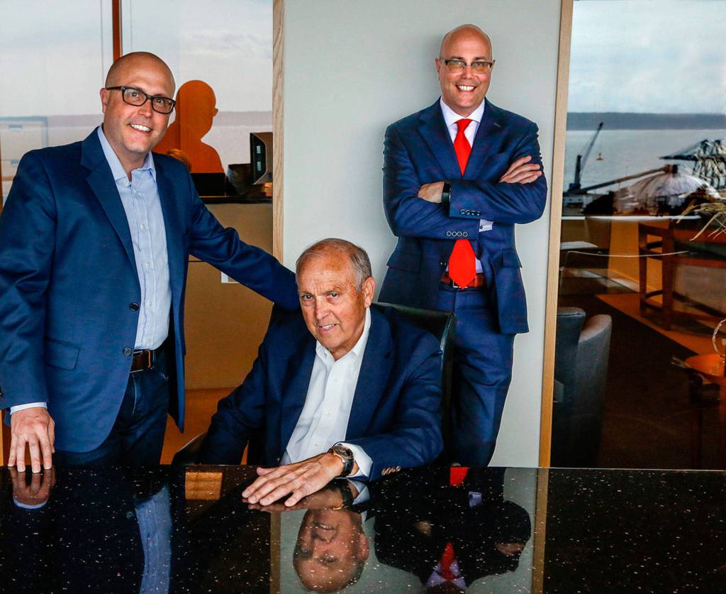 Arthur Skotdal (center) pays a visit to his sons who now head Skotdal Real Estate. With him, in their glassy 12th-floor headquarters in the Key Bank Tower, are Craig Skotdal (left) and Andy Skotdal. (Dan Bates / The Herald)